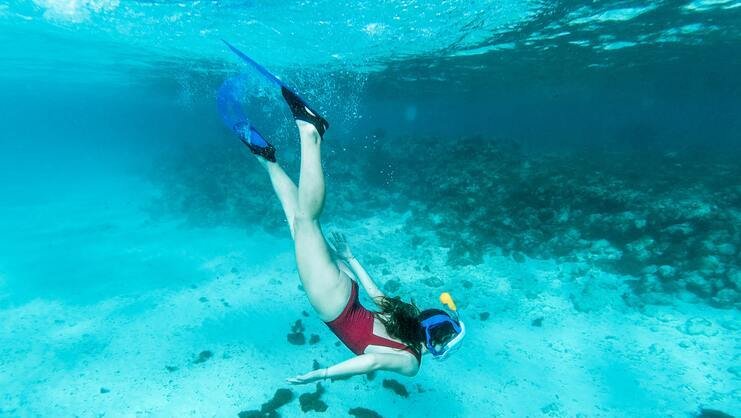 picture of a woman diving about 10 feet underwater