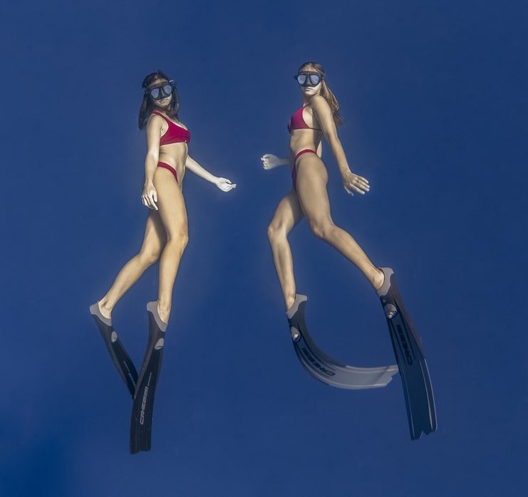 picture of two women free diving underwater